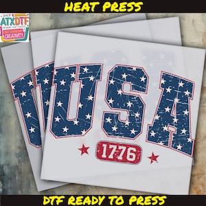 May include: A heat press transfer design featuring the word "USA" in a blue and white distressed font with red stars. The design also includes the year "1776" in a red rectangle.