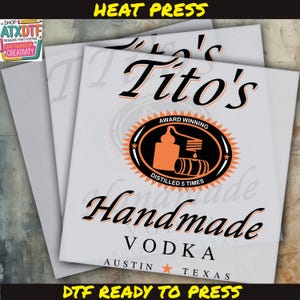 May include: A white heat press transfer design for a Tito's Vodka bottle label. The design features the brand name "Tito's" in a black script font, with the words "Award Winning" and "Handmade Vodka" in a smaller black font. The design also includes a black and orange illustration of a still and barrel, with the text "Distilled 5 Times" underneath. The design is ready to be pressed onto a bottle.