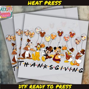 Puede incluir: Un diseño de plancha para planchar con temática de Acción de Gracias con Mickey Mouse, Minnie Mouse, Goofy, Pluto, Donald Duck y Daisy Duck. Los personajes sostienen globos con diseños de otoño y las palabras "THANKSGIVING" están impresas debajo.