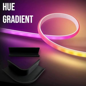 Peut inclure: Une bande LED flexible et éclairée avec un effet de dégradé de couleurs, passant du rose au jaune. Le texte "HUE GRADIENT" est affiché en blanc. Deux supports de montage noirs sont également présentés.
