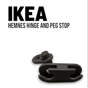 Könnte beinhalten: Schwarze IKEA HEMNES Scharnier- und Stiftelemente. Das Bild zeigt zwei separate Teile, eines mit einem Stift und das andere mit einem gebogenen Design. Das IKEA-Logo und der Produktname sind in schwarzem Text dargestellt.
