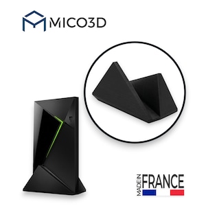 May include: A black MICO3D stand for a media streaming device. The stand features a triangular, angled design to hold the device upright. The image includes the MICO3D logo, a circular inset showing the stand from a different angle, and text reading MADE IN FRANCE with a blue, white, and red flag icon.