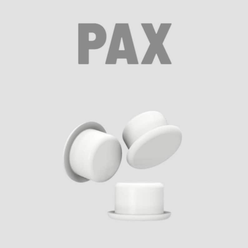 K&ouml;nnte beinhalten: Vor einem hellgrauen Hintergrund werden wei&szlig;e, zylindrische Objekte mit flachen Krempen, die an Miniatur-Zylinderh&uuml;te erinnern, gezeigt. Das Wort "PAX" ist in grauen Blockbuchstaben dar&uuml;ber gedruckt. Die Objekte sind dynamisch angeordnet, einige scheinen zu schweben.