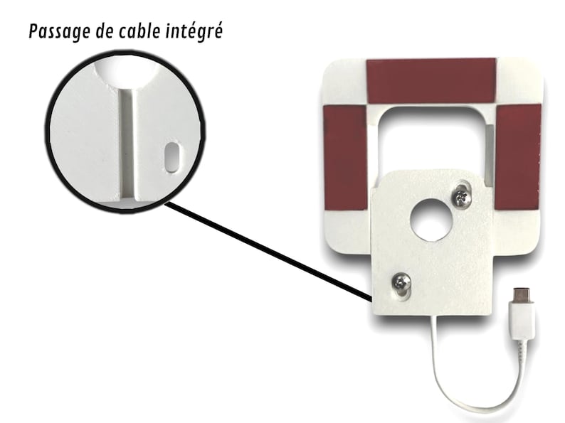 May include: A white, square-shaped device with a rectangular opening and a circular hole. It has four red squares on the corners and a white cable with a USB connector. The text "Passage de cable int&eacute;gr&eacute;" is visible.