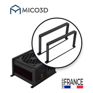Op de afbeelding: Een zwarte voedingseenheid met een ventilatorrooster aan de bovenkant en zijventilatie, vergezeld van twee U-vormige zwarte metalen montagebeugels in een cirkelvormige inzet. Tekst MICO3D en MADE IN FRANCE met vlag.