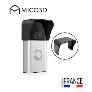 Può includere: Un videocitofono argento e nero con una copertura protettiva nera installata sopra l'obiettivo della fotocamera. Il logo MICO3D è visibile in alto e un pulsante circolare è centrato sulla parte anteriore. È mostrata una vista separata.