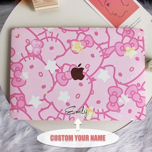 May include: Pink laptop skin with a Hello Kitty design. The skin features multiple Hello Kitty characters with white stars and bows. The skin has a space for a custom name, which is shown as "Emily" in the image.