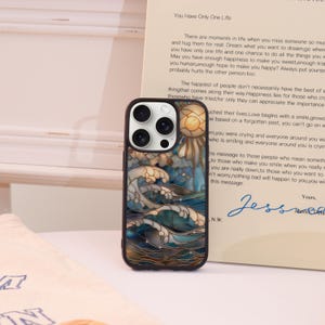 Può includere: Custodia per telefono con un design a vetrata raffigurante onde oceaniche, un sole e un cielo blu. La custodia ha un bordo marrone scuro e una finitura lucida. Il testo sulla custodia non è visibile.