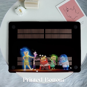 May include: A black laptop case with a printed image of five animated characters. The characters are blue, yellow, green, red, and purple. The characters are standing in front of a black background with a gold grid pattern. The text 'Printed Bottom' is printed in white on the bottom of the case.