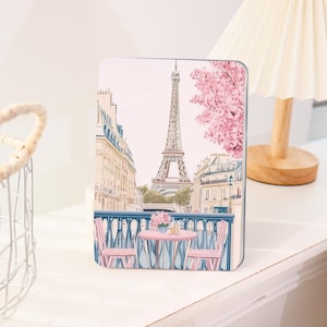 May include: A rectangular decorative panel featuring a Parisian street scene with the Eiffel Tower, pink cherry blossoms, and a cafe table with chairs. The color palette includes pink, blue, and beige tones, creating a romantic aesthetic.