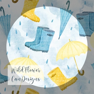 以下が含まれることがあります： 黄色と青のレインブーツ、黄色と青の傘、青い背景に降る雨のしずくを描いた水彩画のシームレスパターン。画像の中央に「Wildflower Can Designs」の文字があります。