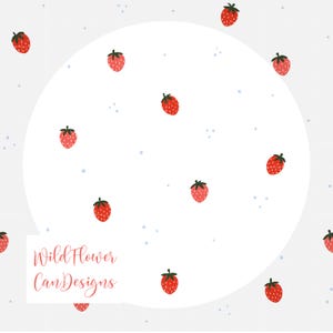 May include: A white background with a grid pattern and a large white circle. Scattered throughout are red strawberries with green tops. Small blue dots are also dispersed. The text "WildFlower CanDesigns" is in the lower left corner.