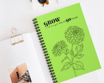 May include: A green spiral notebook with the text "GROW through what you go through" and a black line drawing of two flowers.