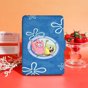 May include: Blue tablet case featuring a cartoon design of SpongeBob SquarePants and Patrick Star in a porthole. The case has a textured background with white flower shapes.