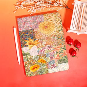 May include: A floral patterned tablet case with a white stylus. The case features a patchwork design with various flower illustrations in shades of yellow, orange, pink, and blue. The background is a solid orange.