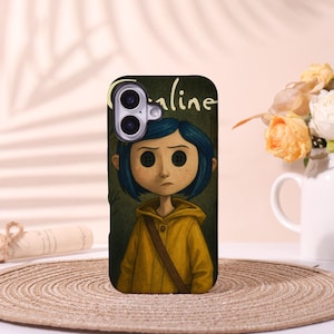 May include: A phone case featuring a cartoon illustration of a girl with button eyes, wearing a yellow raincoat and a blue bob. The word "Caroline" is written in white script above the girl's head. The case has a dark green background.