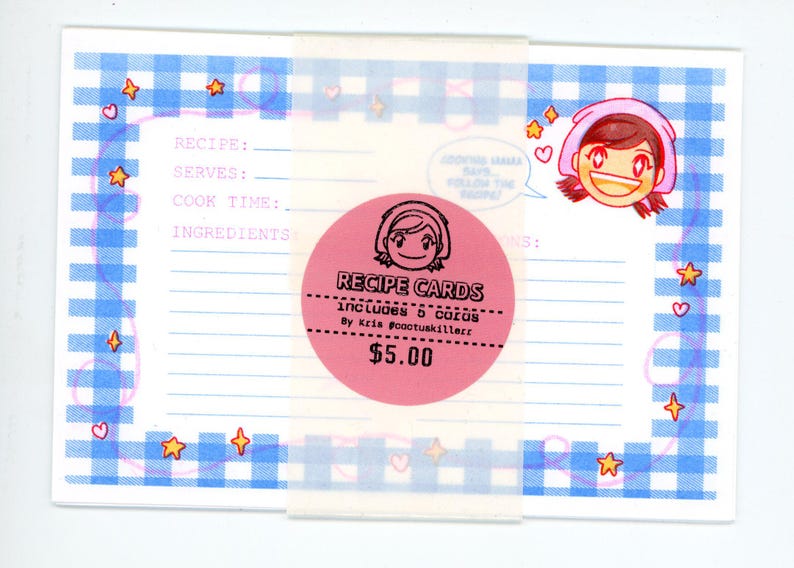 May include: A rectangular recipe card featuring a blue and white gingham border with small orange stars and pink hearts. The card includes printed lines for recipe details and a cartoon character. A pink circular sticker reads RECIPE CARDS.