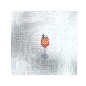 May include: A cross-stitch design of a cocktail in a stemmed glass. The drink is a mix of orange and yellow, with a green garnish. The glass and stem are blue. The background is a light blue grid.
