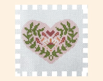 May include: A pink heart-shaped canvas with a floral design in shades of green, brown, and orange. The design is centered on the canvas and is surrounded by a white border.
