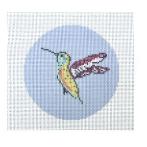 May include: A needlepoint design featuring a colourful hummingbird. The bird has a long beak and is depicted with yellow, green, and red details. The hummingbird is set against a light blue circular background.