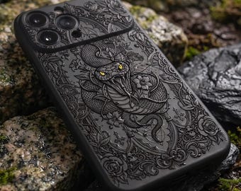 May include: A matte black smartphone case featuring an intricate, embossed design of a coiled snake with striking yellow eyes, surrounded by detailed floral patterns, vines, and small skull motifs across the entire back surface.