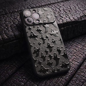 May include: A black smartphone case featuring a repeating embossed pattern of small ghosts and tiny stars across the entire back surface. The case includes a raised rectangular cutout section at the top to accommodate a triple-lens camera system.