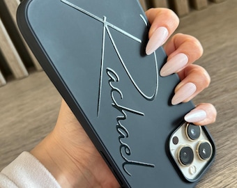 May include: Black phone case with a raised, silver-coloured signature that says "Michael".