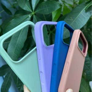 Pu&ograve; includere: Una collezione di custodie per telefoni colorate nei toni del verde, viola, blu e pesca. Le custodie sono realizzate in un materiale liscio e presentano ritagli per la fotocamera e i pulsanti. Proteggono il telefono.