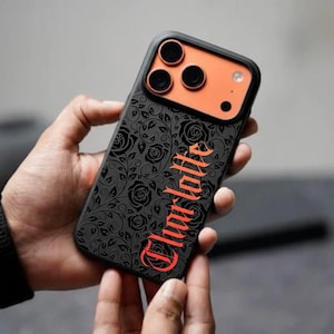 May include: Black phone case featuring a rose design and the name "Charlotte" in red script. The case has a black frame and an orange camera section.