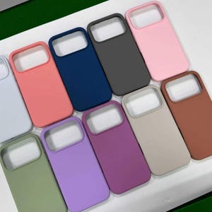 Pu&ograve; includere: Una collezione di custodie per telefoni colorate in varie tonalit&agrave;, tra cui rosa, blu, verde e marrone. Le custodie hanno una finitura liscia e opaca e un design rettangolare con un ritaglio per la fotocamera. Le custodie sono progettate per proteggere il telefono.