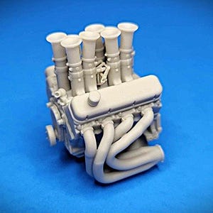 Könnte beinhalten: Ein detailliertes Modell eines grauen Motors mit mehreren Ansaugkrümmern und einem großen Auspuffkrümmer. Der Motor ist aus Kunststoff und für den Modellbau konzipiert.