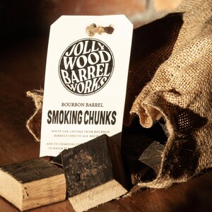 May include: White oak smoking chunks from bourbon barrels used to age bourbon. The label reads "Jolly Wood Barrel Works Bourbon Barrel Smoking Chunks".