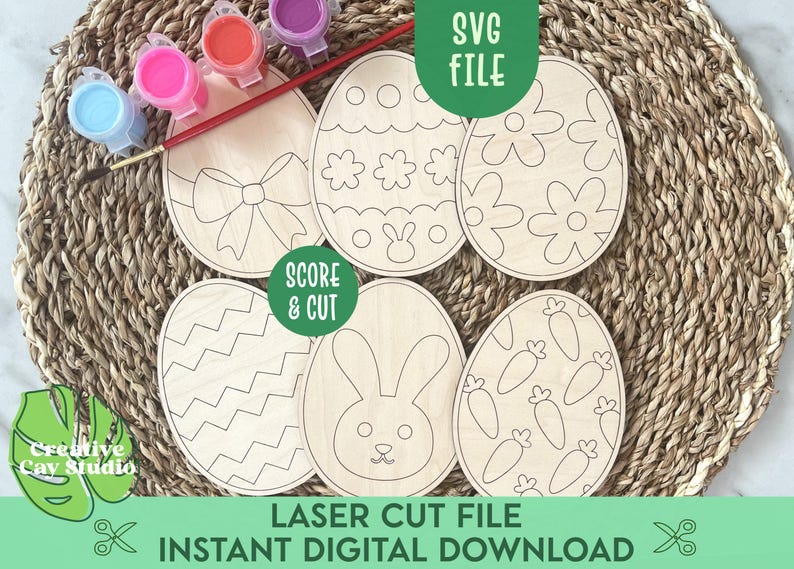 May include: Six unfinished wooden Easter egg shapes with different designs, including a bunny, carrots, flowers, and zigzags. The eggs are ready to be painted and decorated. The image also includes paint pots and a paintbrush.