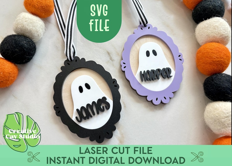 May include: Two Halloween-themed ornaments with ghost designs, one black and one lavender, each with a name. The ornaments hang from a black and white striped ribbon. The text "SVG FILE" and "LASER CUT FILE INSTANT DIGITAL DOWNLOAD" are also visible.