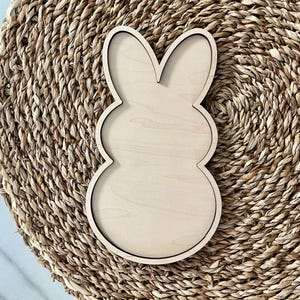 May include: A wooden bunny-shaped cutout, perfect for crafting and decorating. The cutout is unfinished and ready to be painted or stained.