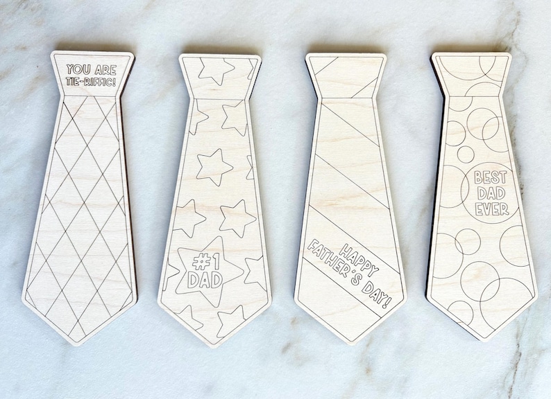 May include: Four wooden tie-shaped ornaments with various designs and text. One tie has a diamond pattern and reads "YOU ARE TIE-RIFFIC!". Another has stars and "#1 DAD". A third says "HAPPY FATHER'S DAY!". The last says "BEST DAD EVER".