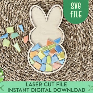 May include: A wooden bunny shaped puzzle with a cutout for a mosaic of colorful tiles. The puzzle is on a woven straw mat. The text "SVG FILE" is in a green box at the top of the image. The text "LASER CUT FILE INSTANT DIGITAL DOWNLOAD" is at the bottom of the image.