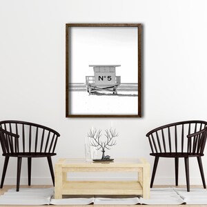 May include: Black and white photograph of a lifeguard stand on a beach. The stand is numbered "N&deg; 5".