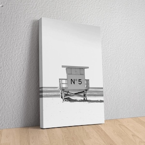 May include: Black and white photograph of a lifeguard stand on a beach. The stand is labeled "N&deg; 5".