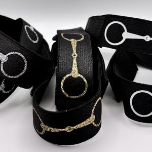 Peut inclure: Un ensemble de bandeaux élastiques noirs avec un motif de mors équestre argenté, doré ou blanc. Les bandeaux sont faits d'un matériau doux et extensible et sont parfaits pour ajouter une touche de style équestre à n'importe quelle tenue.