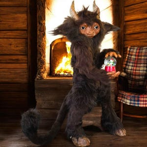May include: A dark brown, furry creature with horns and a tail, holding a snow globe. The creature has a human-like face and is standing in front of a fireplace. A plaid armchair is in the background.