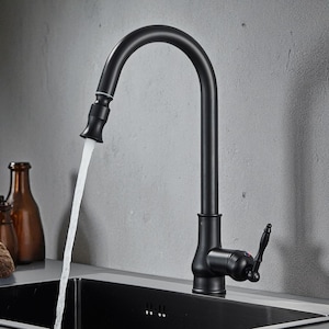 Pode incluir: Uma torneira de cozinha preta fosca com um bico de arco alto, dispensando um fluxo de água. A torneira apresenta um design de alça única e é definida em um fundo cinza neutro. A torneira é montada em uma pia preta.