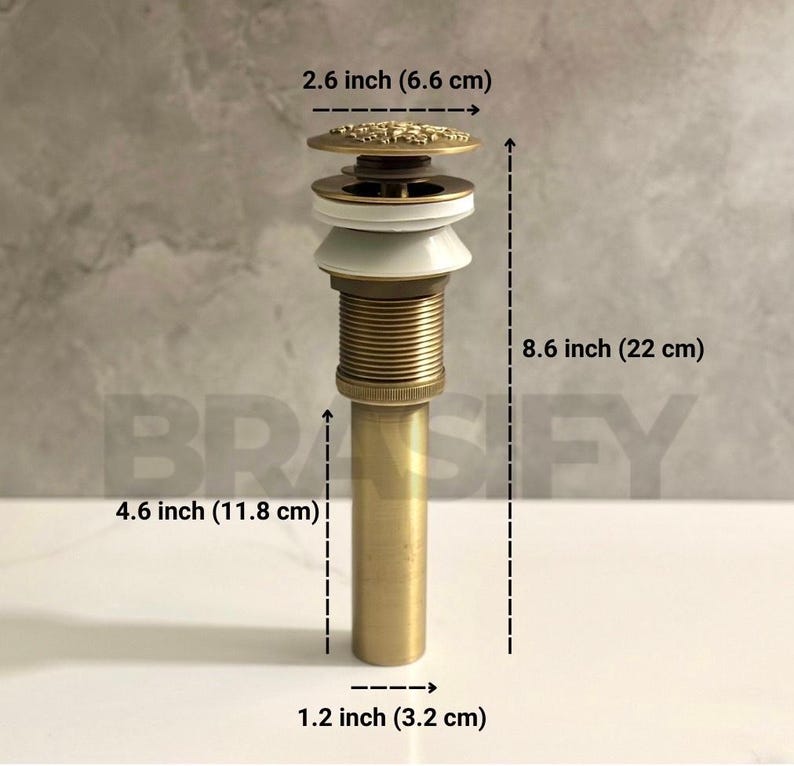 May include: A gold-toned bathroom sink drain with a decorative top. The drain is 8.6 inches (22 cm) tall, 4.6 inches (11.8 cm) wide, and 1.2 inches (3.2 cm) in diameter.