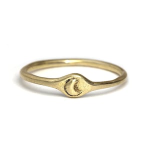 May include: A gold ring featuring a crescent moon design.