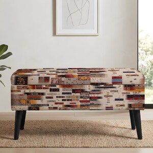 Peut inclure: Un banc de rangement rectangulaire doté d'un revêtement en tissu crème avec un motif multicolore composé de blocs aux textures tissées et formes géométriques variées. Le banc repose sur quatre pieds fuselés en bois noir mat.
