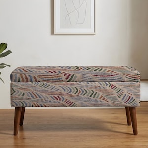 May include: A rectangular storage bench featuring a textured fabric upholstery with a repeating pattern of curved, multi-colored lines in shades of red, blue, green, and beige. The bench is supported by four tapered, dark brown wooden legs.
