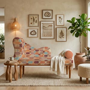 May include: A chaise lounge with a colorful geometric pattern, wooden legs, and a rolled bolster pillow. A white blanket is draped over the lounge. The room features framed botanical prints and a large potted plant.