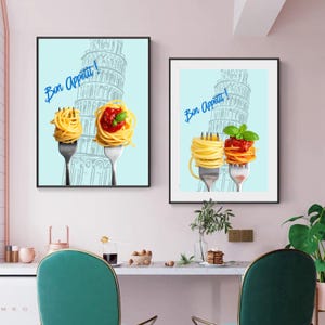 May include: Two framed prints with a light blue background, depicting spaghetti on forks with the Leaning Tower of Pisa. One fork holds plain pasta, the other holds pasta with tomato sauce and basil. The phrase "Bon Appetit!" is written in blue.