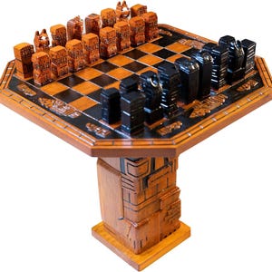 Könnte beinhalten: Ein Schachspiel aus Holz mit aufwendig geschnitzten Figuren in Braun und Schwarz. Das Schachbrett ist achteckig, mit einem dunklen Rand und einer karierten Spielfläche. Das Set ist auf einem passenden Holzsockel montiert.