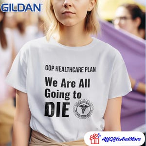May include: White Gildan t-shirt with the text "GOP HEALTHCARE PLAN We Are All Going to DIE" in black. The shirt also features a medical symbol. The shirt is being worn by a person.